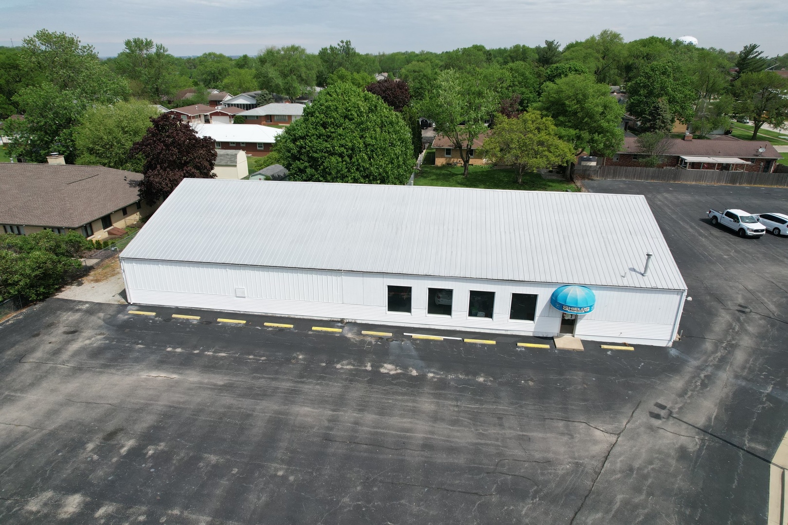 an aerial view of a house with a yard and trees