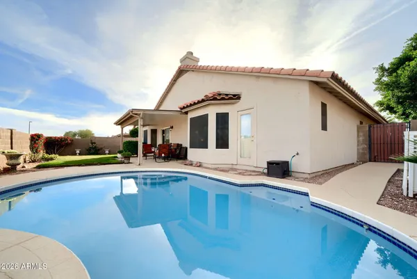 a view of a house with pool and chairs