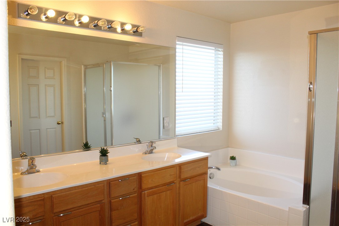 207 Priority Point Street Henderson, NV 89012 - Photo 22 of 38 Full bathroom with a bath, double vanity, and a shower stall