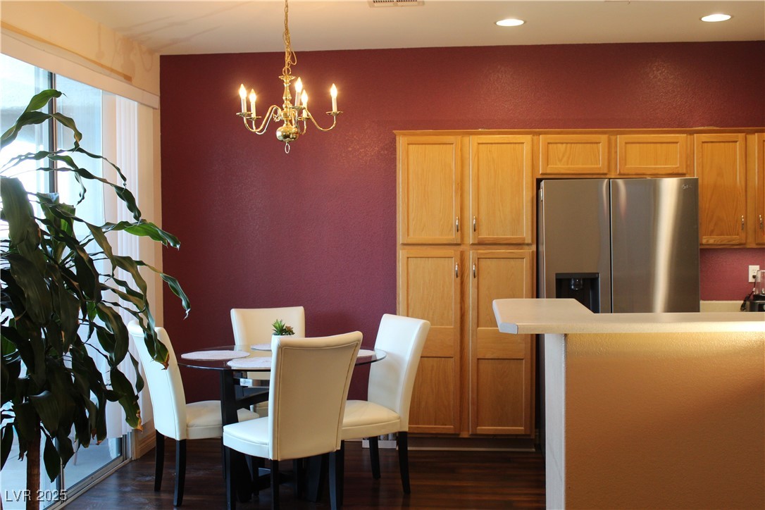 207 Priority Point Street Henderson, NV 89012 - Photo 6 of 38 Dining space with dark wood-type flooring, a textured wall, a chandelier, and recessed lighting