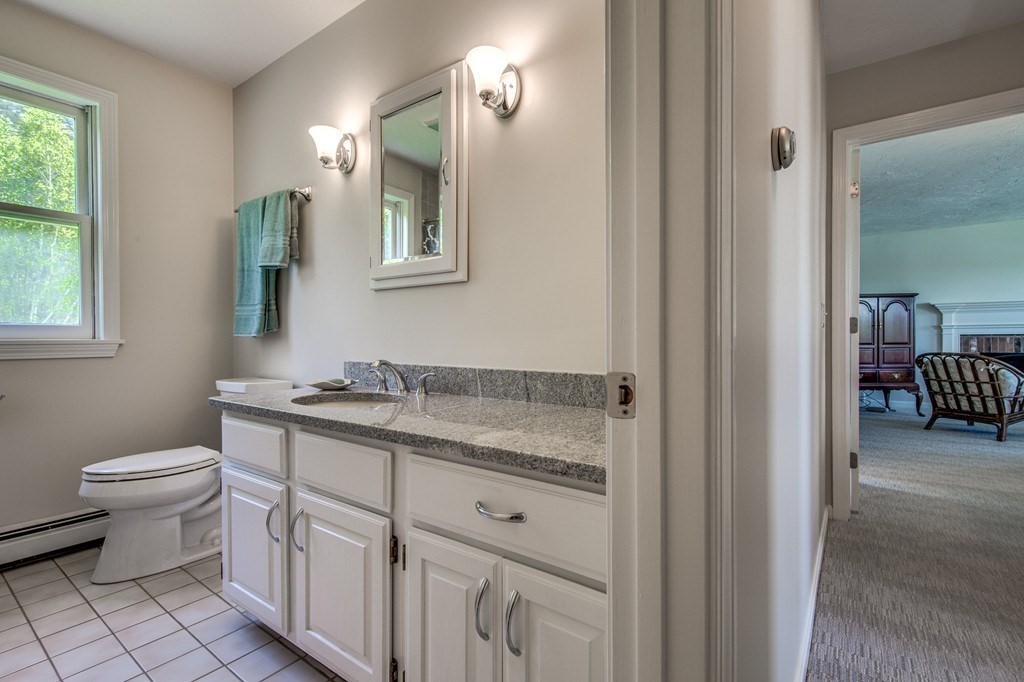 128 Princeton Road Sterling, MA 01564 - Photo 13 of 31 a bathroom with a granite countertop toilet a sink and a mirror