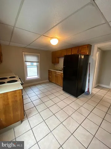 a kitchen with a refrigerator and white cabinets