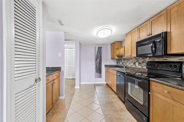 a kitchen with stainless steel appliances granite countertop a refrigerator and a stove