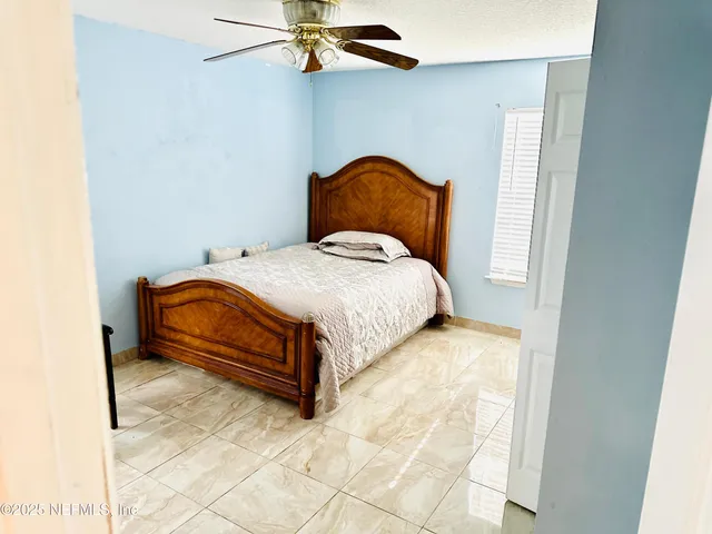 a bedroom with a bed and ceiling fan