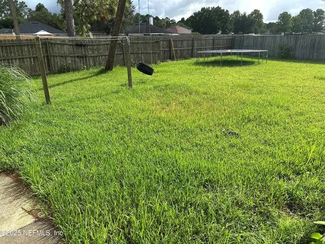a view of a backyard with a fence