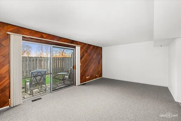an empty room with sliding door and balcony