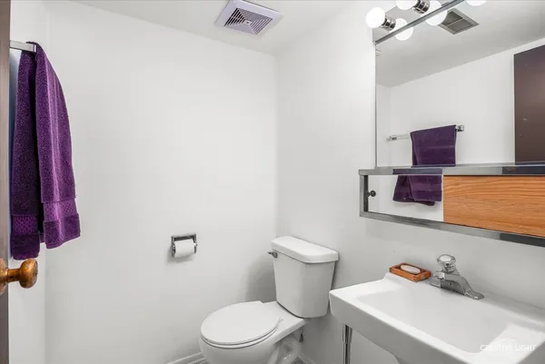 a white toilet sitting next to a bathroom sink
