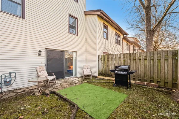 a backyard of a house with wooden floor and outdoor seating