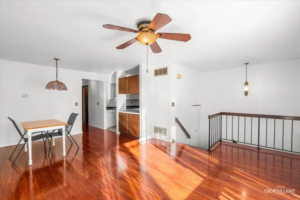 a view of a livingroom with furniture a ceiling fan and wooden floor