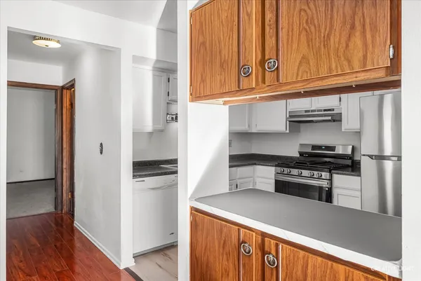 a kitchen with stainless steel appliances granite countertop a refrigerator and a stove top oven