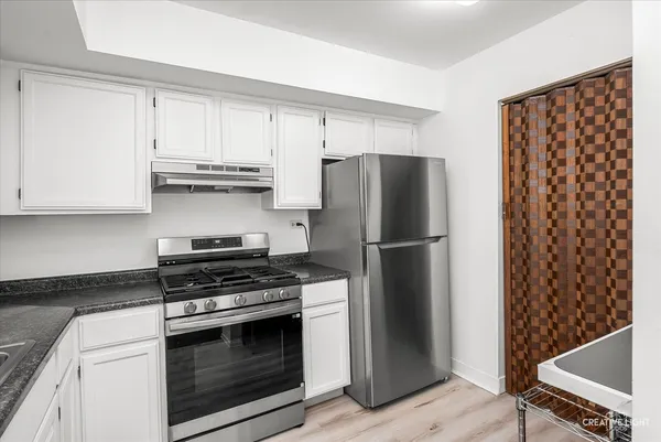 a kitchen with stainless steel appliances a refrigerator stove and cabinets