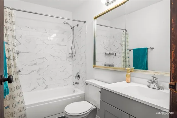 a bathroom with a granite countertop sink mirror toilet and bathtub