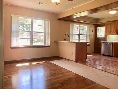 a view of a kitchen with wooden floor and a window