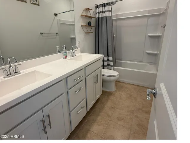 a spacious bathroom with a granite countertop sink a toilet mirror and shower