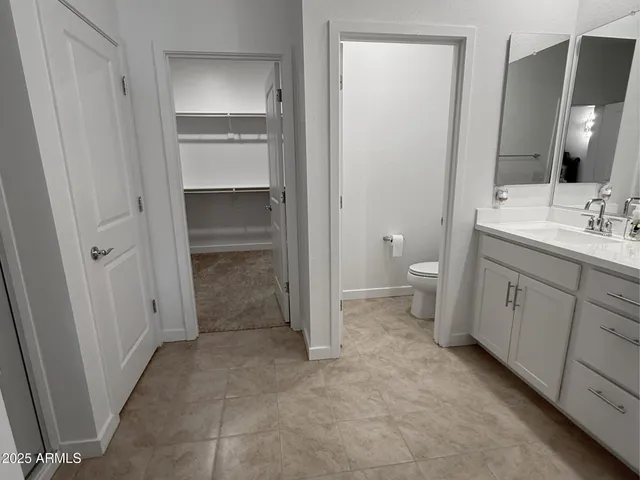 a bathroom with a granite countertop sink a toilet and a mirror