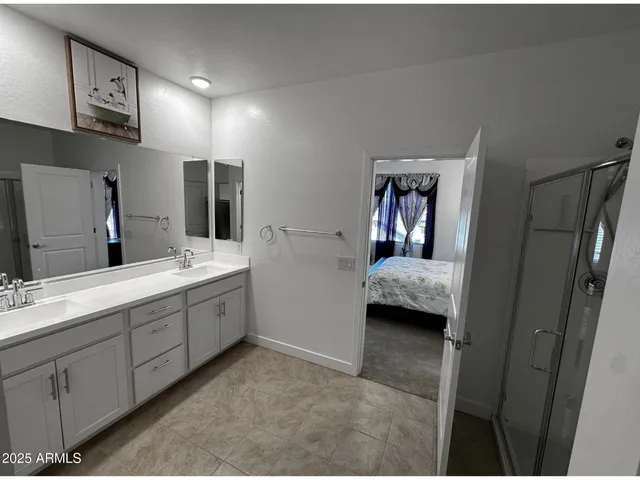 a en suite bathroom with a double vanity sink and mirror