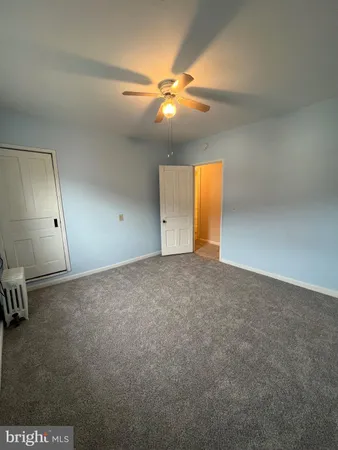 an empty room with a ceiling fan and window