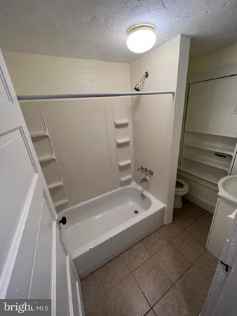 a bathroom with a tub a toilet and a sink