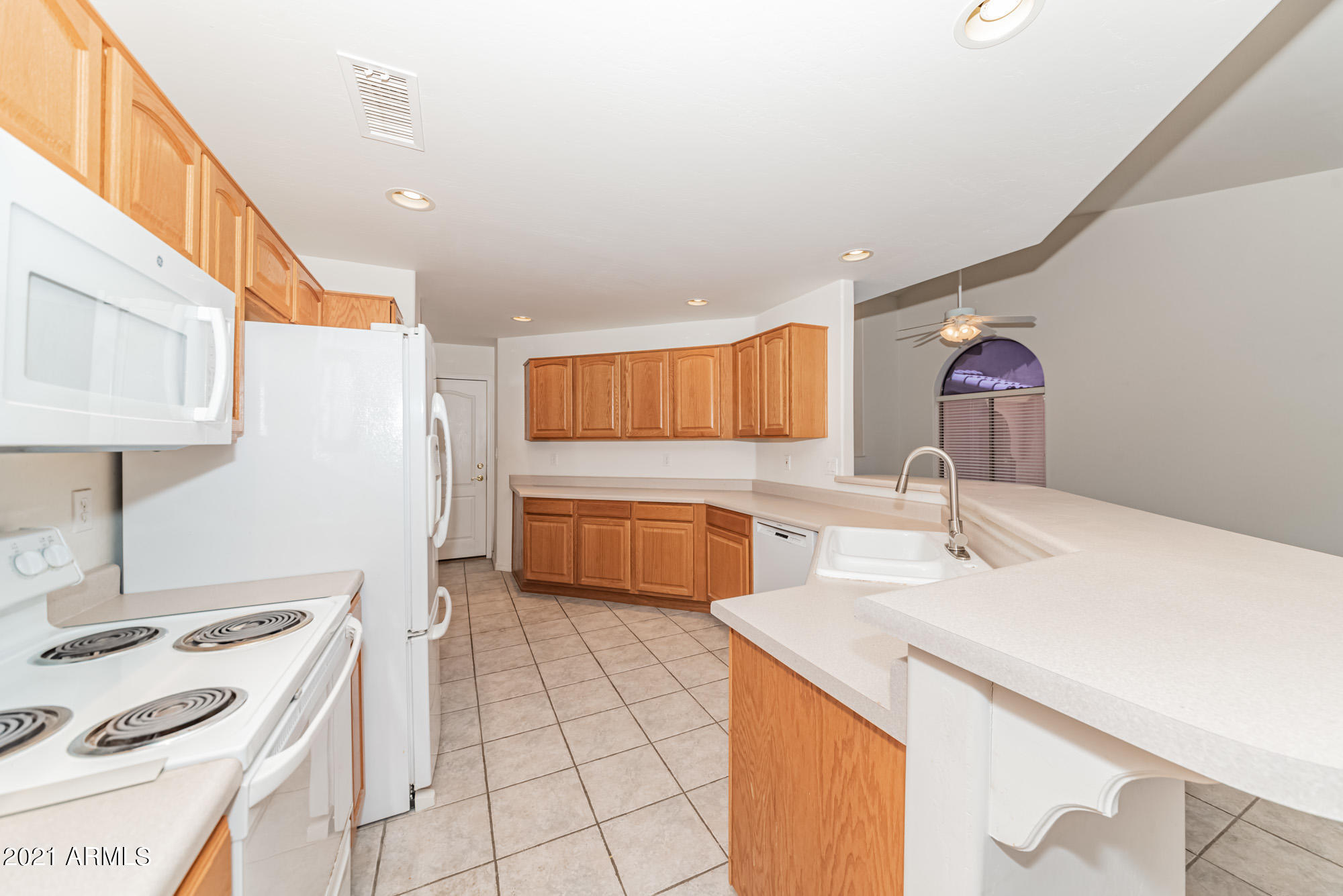 5830 East McKellips Road, Unit 56 Mesa, AZ 85215 - Photo 11 of 47 a kitchen with a sink a stove top oven a counter space and cabinets