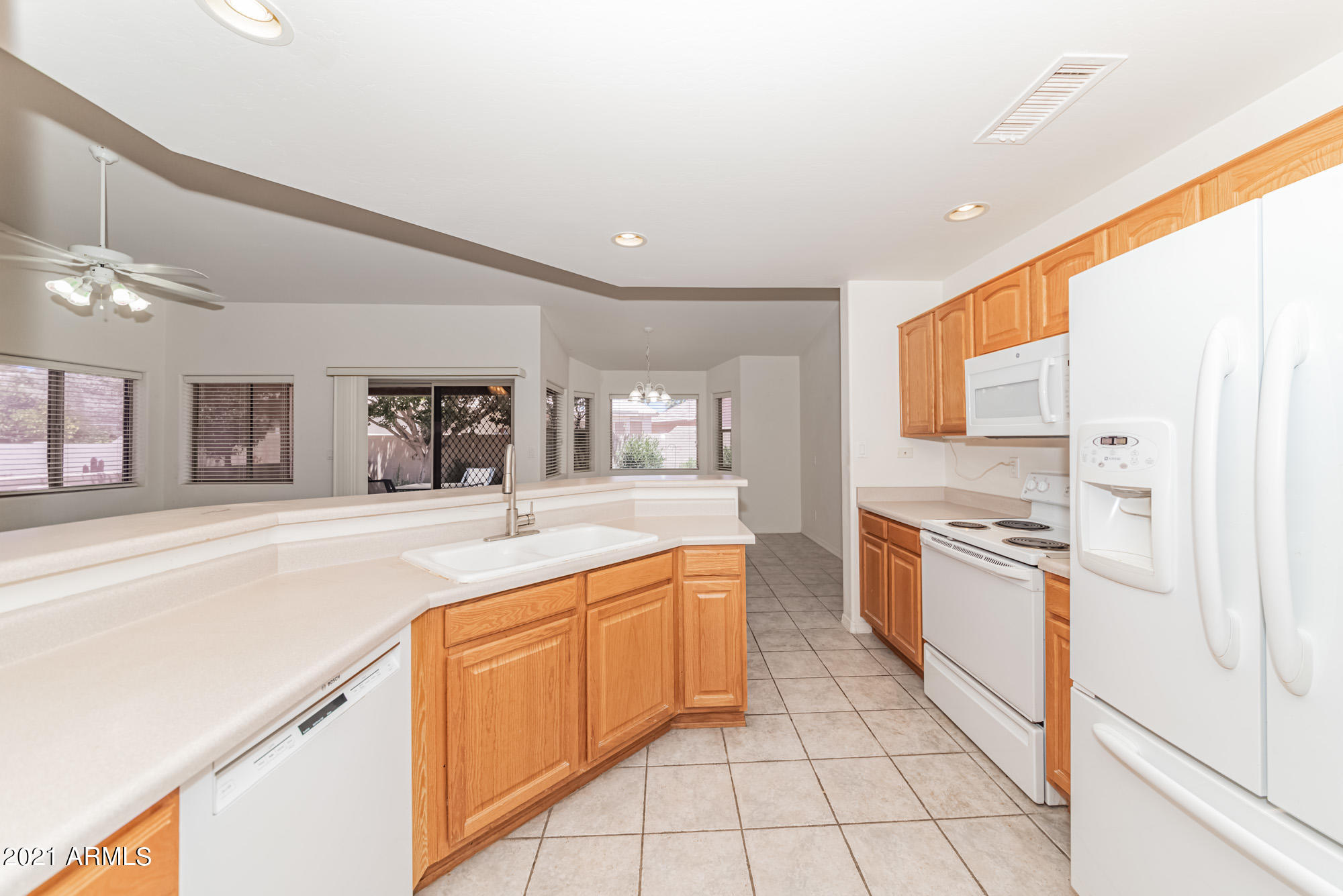 5830 East McKellips Road, Unit 56 Mesa, AZ 85215 - Photo 13 of 47 a large kitchen with granite countertop a sink and white cabinets