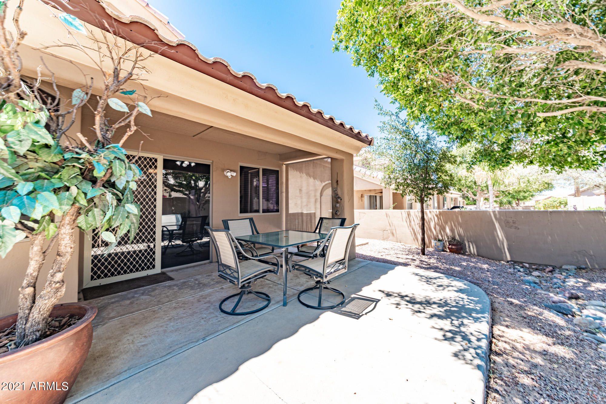 5830 East McKellips Road, Unit 56 Mesa, AZ 85215 - Photo 28 of 47 a view of a patio with a dining table and chairs with wooden floor