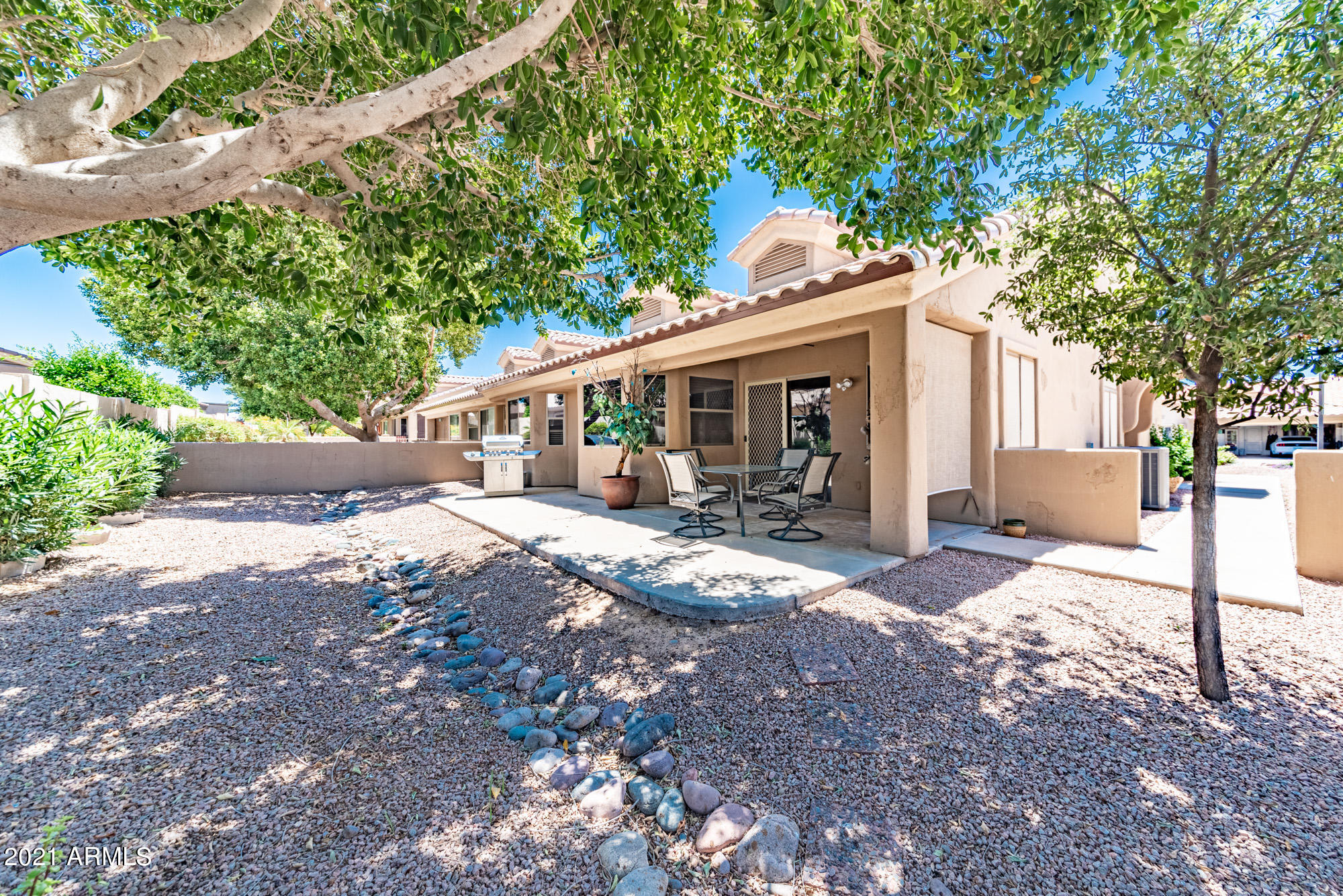 5830 East McKellips Road, Unit 56 Mesa, AZ 85215 - Photo 29 of 47 a view of a patio with chairs and a large tree