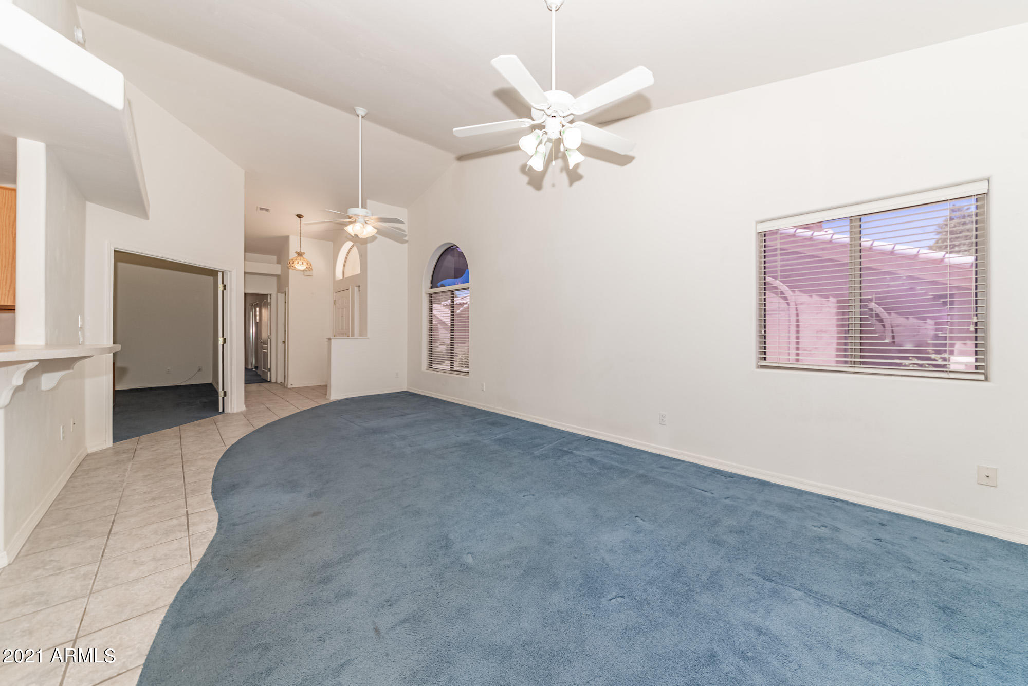 5830 East McKellips Road, Unit 56 Mesa, AZ 85215 - Photo 8 of 47 an empty room with a chandelier fan and windows
