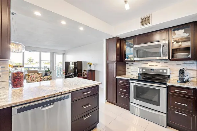 a kitchen with stainless steel appliances kitchen island granite countertop a stove sink and microwave