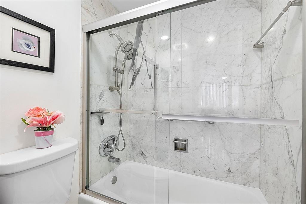 3300 Northeast 36th Street, Unit 303 Fort Lauderdale, FL 33308 - Photo 18 of 53 a bath tub sitting next to a white sink and vanity