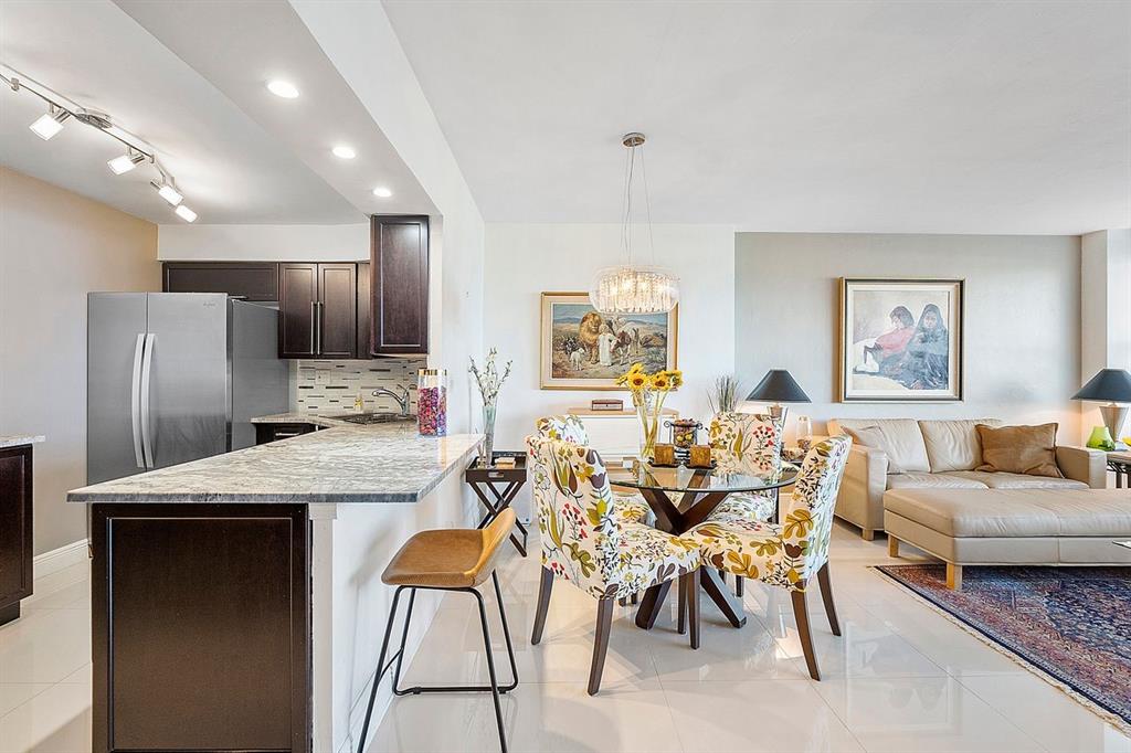 3300 Northeast 36th Street, Unit 303 Fort Lauderdale, FL 33308 - Photo 7 of 53 a living room with stainless steel appliances kitchen island granite countertop furniture and a wooden floor