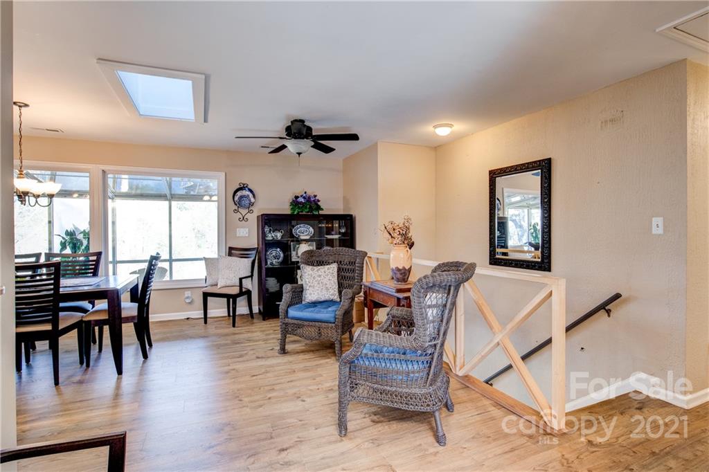 10043 Tepa Place Tega Cay, SC 29708 - Photo 4 of 32 a dining room with wooden floor a glass table and chairs