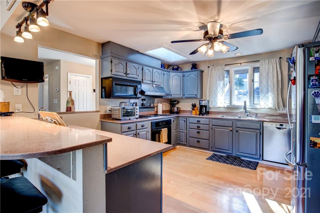 10043 Tepa Place Tega Cay, SC 29708 - Photo 8 of 32 a kitchen with stainless steel appliances kitchen island granite countertop a sink refrigerator stove and microwave