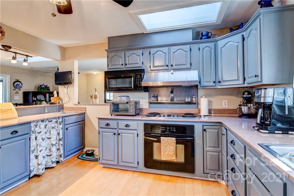 10043 Tepa Place Tega Cay, SC 29708 - Photo 9 of 32 a kitchen with stainless steel appliances granite countertop a stove top oven a sink dishwasher and cabinets with wooden floor