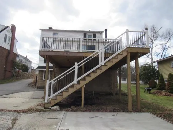 a view of a roof deck with couches under an umbrella