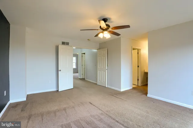 a view of empty room with window and ceiling fan