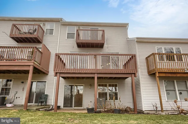 a view of a brick house with many windows and a yard