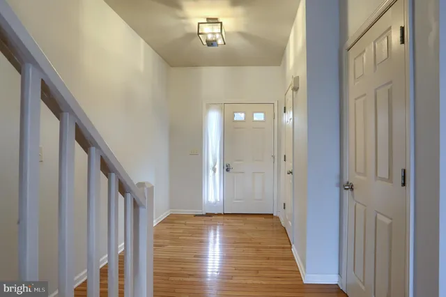 a view of a hallway with wooden floor and staircase
