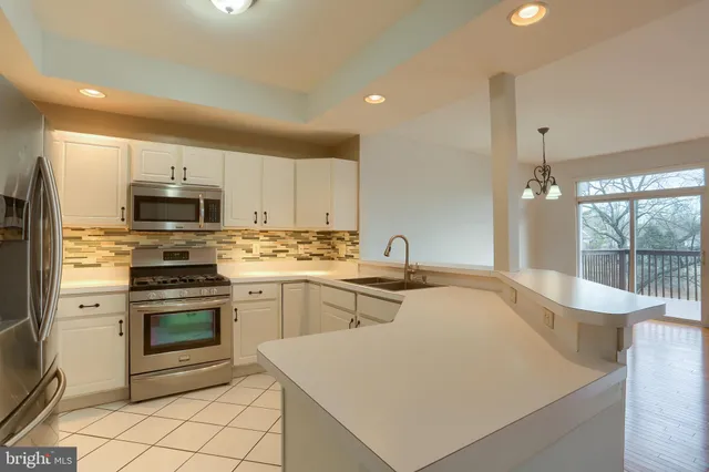 a kitchen with appliances a sink and cabinets