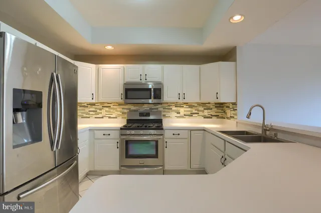 a kitchen with stainless steel appliances granite countertop a refrigerator sink and stove