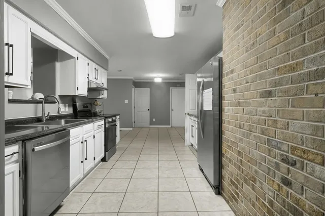 a kitchen with stainless steel appliances granite countertop a refrigerator and a stove
