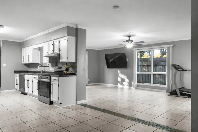 a view of kitchen with sink cabinets and window