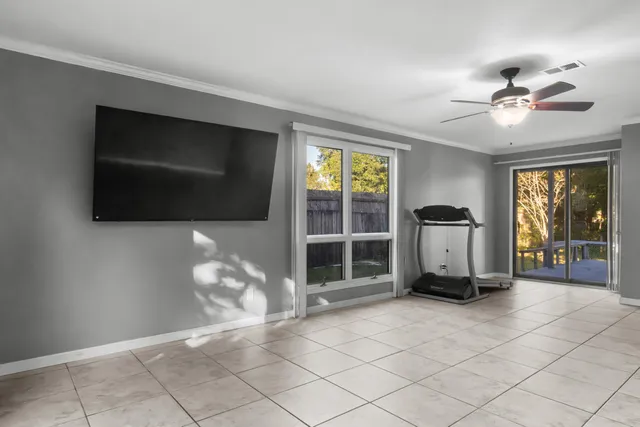 a living room with furniture a flat screen tv and a floor to ceiling window