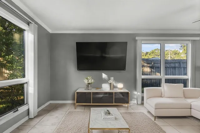 a living room with a flat screen tv and a floor to ceiling window