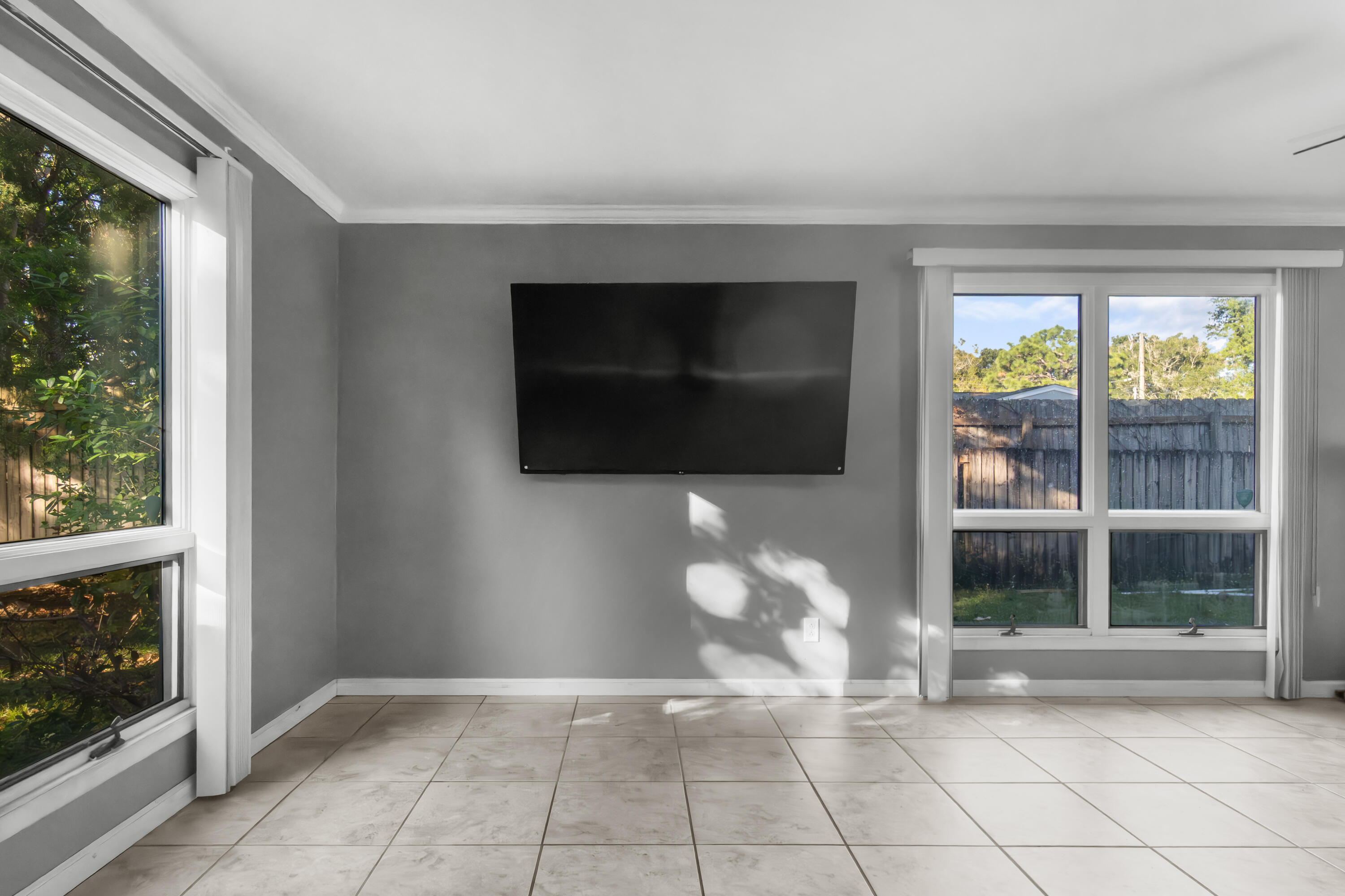 512 Lang Road Fort Walton Beach, FL 32547 - Photo 18 of 51 a living room with a flat screen tv and a floor to ceiling window