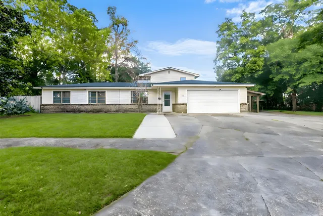 a view of a house with a yard and sitting area