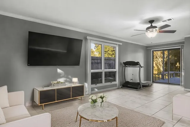 a living room with furniture a flat screen tv and a window