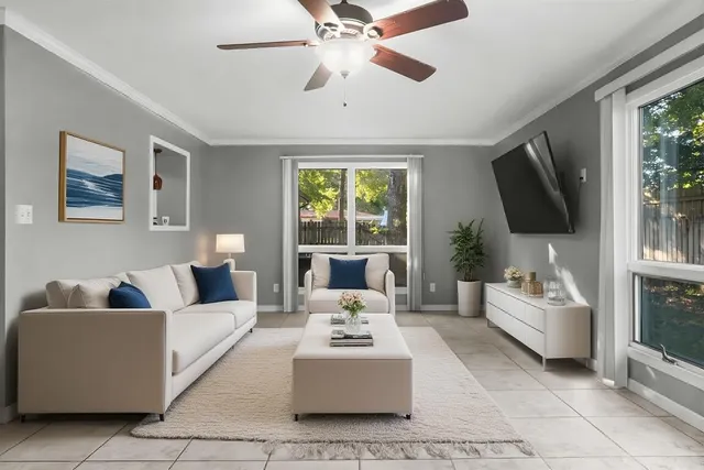 a living room with furniture a flat screen tv and a large window