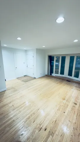 a view of an empty room with wooden floor
