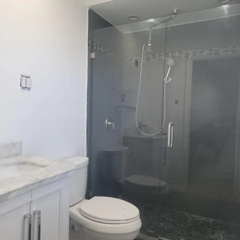 a bathroom with a granite countertop sink toilet and shower