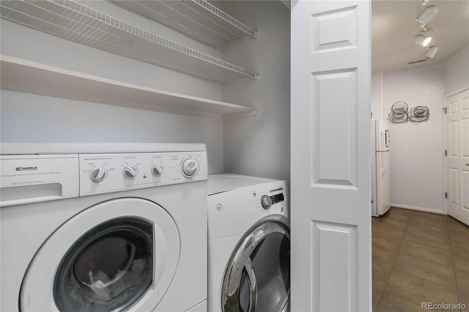 5255 Memphis Street, Unit 702 Denver, CO 80239 - Photo 14 of 30 a view of washer and dryer with kitchen in the background